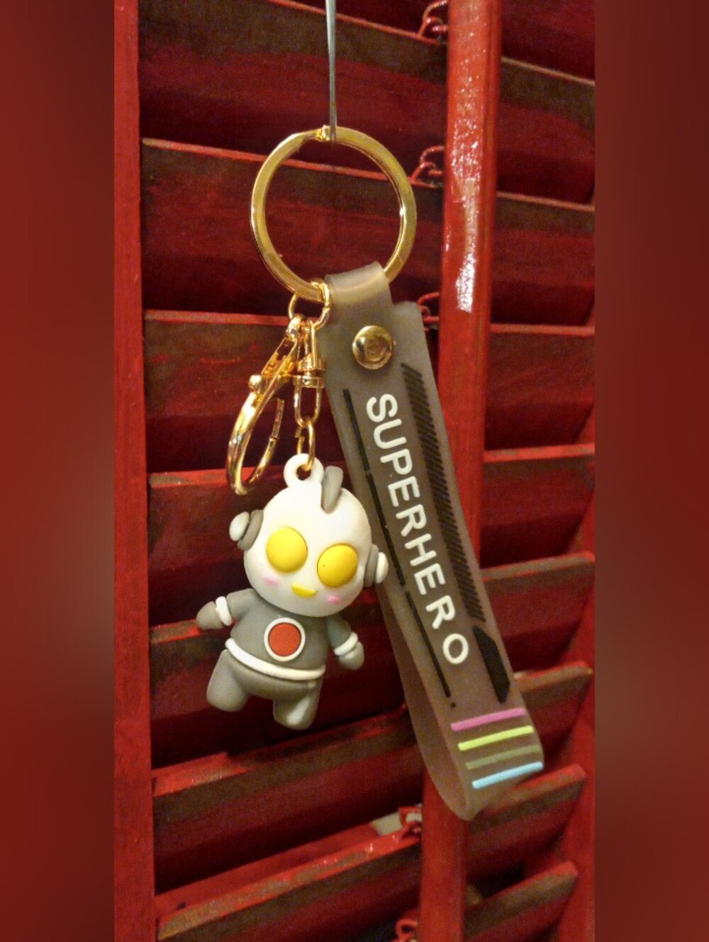 Gray Superhero Keychain Phone Accessory with Yellow Accents